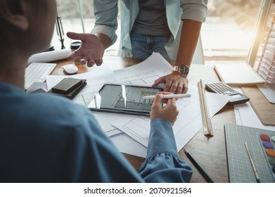Architects and interior designers women discussing to concept of building design. Estimation for construction project with tablet technology, Drawing, Material and Model. Selective focus center image