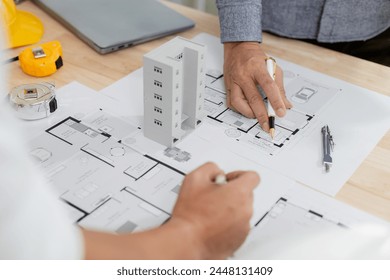 Architects at a meeting discussing house plans are reviewing draft house plans. Projects assigned by customers and customized design before delivery Interior design and decoration ideas - Powered by Shutterstock