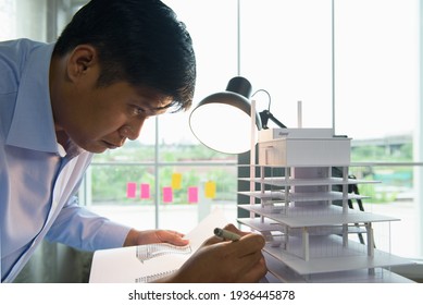 Architects worked thinking design architecture with building model, Design from his idea stationery on desk office. Startup and analysis of the architecture of building structure.