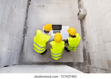 Architects and worker at the construction site. - Shutterstock ID 717437401