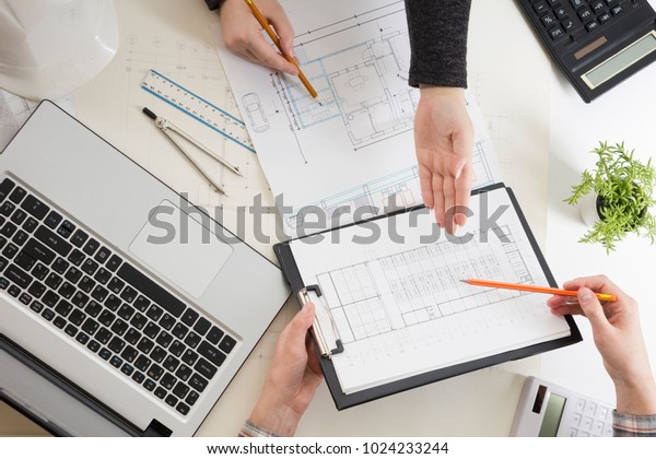 Architects working on blueprint, real estate
project. Architect workplace - architectural project, blueprints,
ruler, calculator, laptop and divider compass. Construction
concept. Engineering
tools.