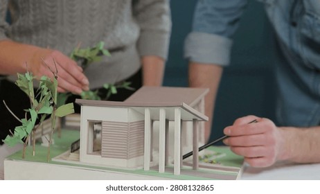 Architects are working on a building model in the office. Designer are developing architecture design. Architect and Engineer Work with Buildings Model. concept of construction and urban planning.
