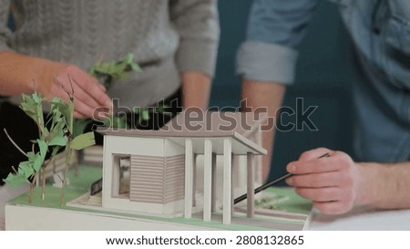 Architects are working on a building model in the office. Designer are developing architecture design. Architect and Engineer Work with Buildings Model. concept of construction and urban planning.