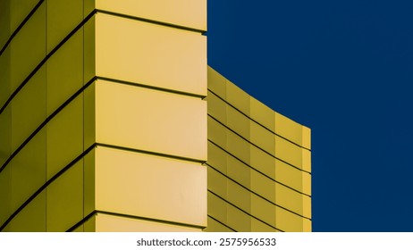 architectural abstract pattern fragment of a wall of a yellow modern building on a blue background
