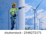 Architectural american engineer in hardhat working with mobile phone on wind turbines at electricity power station background. Renewable energy, wind turbine generate electricity to produce energy .