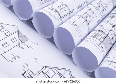 Architectural Blueprints And Blueprint Rolls And A Drawing Instruments On The Worktable. Drawing Compass, Plans. Civil Engineering, Construction Background.