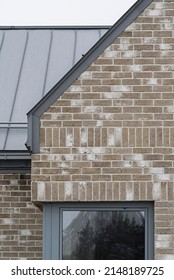 Architectural Detail For Building, Single Family House. Roof Made Of Aluminum Sheet In Gray Color. Walls Made Of Brick And Window Woodwork In Grey Color. British Style Of The Building.