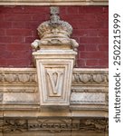 Architectural detail of the V for Queen Victoria, on the facade of the historic Royal Albert Hall in Kensington, London, UK.