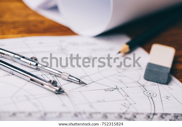 Architectural drawings. Architectural prints and\
print rolls and a drawing instruments on the worktable. Drawing\
compass, plans.