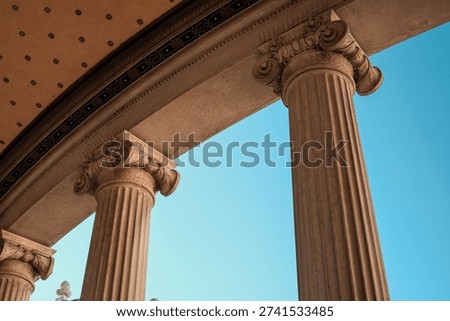 Architectural elegance: classical columns under a clear blue sky.