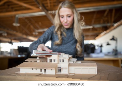 Architectural engineer artist creating and working in the office on design with scale model home - Powered by Shutterstock