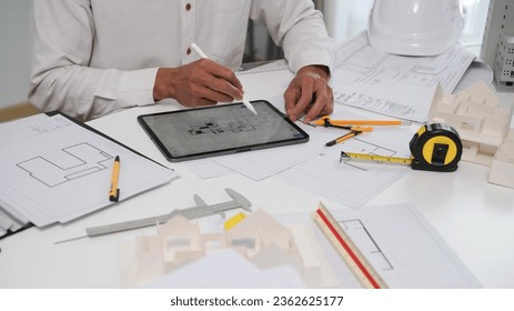 Architectural engineer man using digital tablet on workspace..