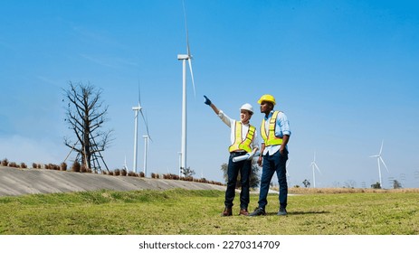 Architectural engineer teamwork people working his blueprints discussing renewable wind turbine generate electricity to produce energy. renewable energy concept.