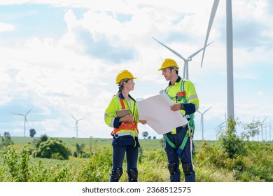 Architectural engineering worker builders looking for wind turbine blueprint drawings for wind turbine construction at windmill field farm. Alternative renewable energy for clean energy concept. - Powered by Shutterstock