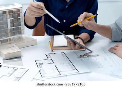 Architectural or engineers are explaining construction plans using tablets and brainstorming ideas for a successful construction project.