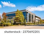 Architectural facade building with of glass elements. Exterior of a modern industrial building. Modern Business Gray Contemporary Building in Urban Street Setting. Corner Business Building