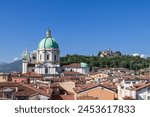 The architectural heritage of Brescia unfolds with the Cathedral of Santa Maria Assunta dome rising above rooftops, backed by the medieval castle atop a lush hill