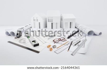 architectural model of houses on blueprint with measurement and drawing technical tools, desk for building construction plan, interior designer and architect work, isolated on white background