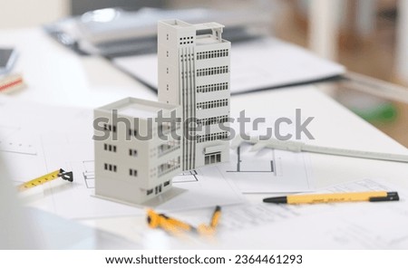 Architectural model on desk with laptop, drawing technical tools and blueprints. Architecture, building, construction and real estate business.