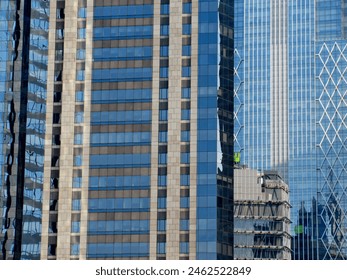 An architectural photograph of a dense composition of multiple skyscrapers with varying facade designs, ranging from stone-clad sections to sleek glass curtains. The central building features a rhythmic pattern of rectangular windows framed by light brown masonry, while the building to the right displays a modern blue glass exterior with a distinctive white diamond-shaped lattice overlay. Distorted reflections of neighboring structures are visible on the polished glass surfaces, creating a complex visual layering of the urban environment. A close-up photograph.