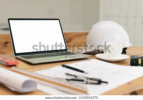Architectural plan, laptop, dividers ,pencil\
,pen ,ruler, glasses and smartphone and blueprint on wooden table.\
Architectural blueprints office desk background construction\
project ideas\
concept.