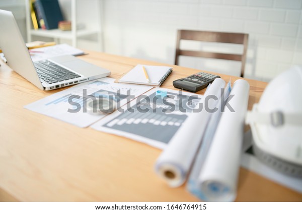 Architectural\
plans Laptop, calculator pencil pen and ruler on the table, Concept\
architects, engineer compass equipment architects On the desk with\
a blueprint in the office,Selective\
Focus