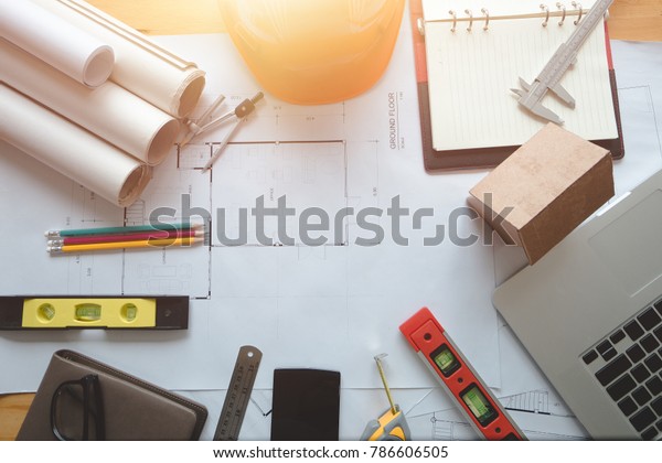 Architectural plans work space top view.\
Architectural project, blueprints,pencil and divider compass on\
wooden desk table.Construction background.Engineering tools. Copy\
space.Architectural\
Concept