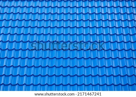Architectural textured background of blue roof metal tile. Roof of a house with modern metal roof tiles