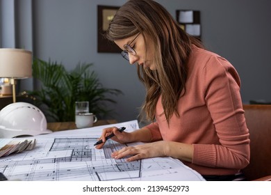 Architecture, Building, Construction And Real Estate Concept - Happy Smiling Female Architect With Blueprint, Ruler And Living House Model On Table Working At Home Office. Architect Woman.