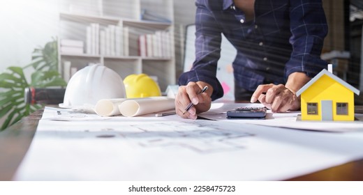 Architecture or Civil engineer analyze with construction blueprint. plan, engineer sketching a construction project, green energy concept - Shutterstock ID 2258475723