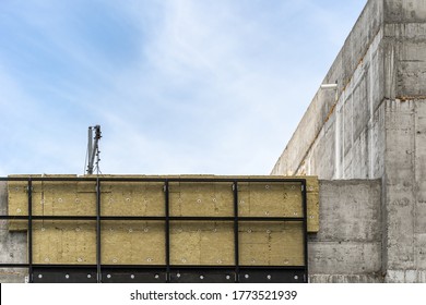 El concepto de arquitectura. Elemento de construcción moderna con aislamiento de lana rocosa en el exterior y espacio de copia en la pared de hormigón, contra el cielo azul en el fondo