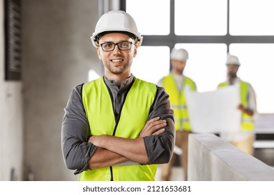 architecture, construction business and building concept - happy smiling male architect in helmet and safety west at office - Powered by Shutterstock