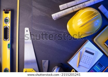 Architecture and construction concept. Blueprints and contractor equipment on grey tiles. Top vie shot.