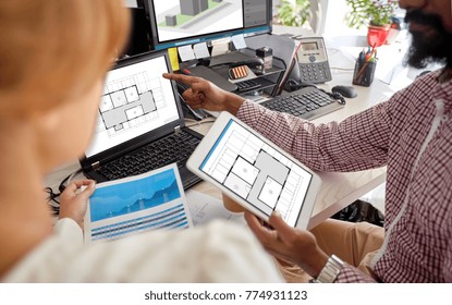 Architecture, Construction And Technology Concept - Architectors Team With Blueprints On Laptop And Tablet Pc Computer Screens At Office