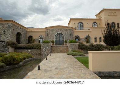 Architecture and design. View of a colonial mansion facade and entrance. A rock path leads the way over the pit filled with water. 