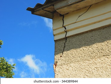 Architecture detail of damaged house corner dilapidated old building facade wall over blue sky background. Private abandoned home fall to ruin. Exterior House