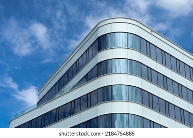 Architecture details Modern Building Glass facades. skyscraper
with a cloudy sky at the background. curved window reflections 