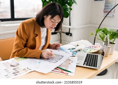 Architecture and interior design concept. Young businesswoman architect choosing materials and details for creating interior design project in studio. Freelancer woman working in a modern office