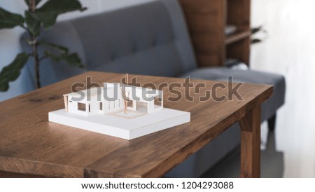 An architecture model on wooden table in office with blur nature background