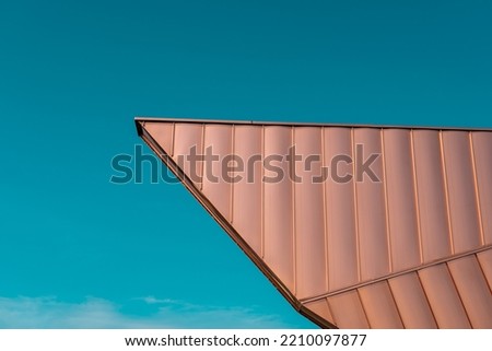 Architecture roofing detail. Cooper elevation panels in a dynamic shape. Modern architecture. Teal and orange.