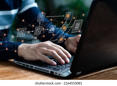 Archiving, Finding, And Managing Business Files And Information Software. IT Expert Works On Laptop Computer In Workplace Setting Up Document Management System (DMS).