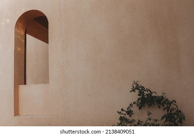 An arch-shaped window in the wall of the building. Light shadows on the wall. Minimal boho style in architecture. Egyptian house exterior with the arch in the wall.