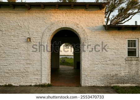 The archway of the rustic building frames a stunning outdoor lan