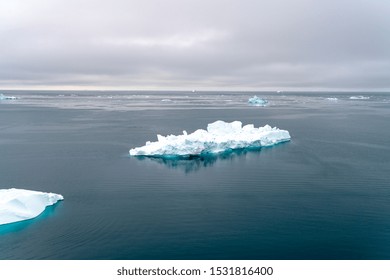 Arctic Icebergs Greenland In The Arctic Sea. You Can Easily See That Iceberg Is Over The Water Surface  And Below The Water Surface. Sometimes Unbelievable That 90% Of An Iceberg Is Under Water 