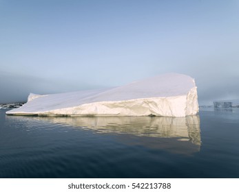 Arctic Icebergs Greenland In The Arctic Sea. You Can Easily See That Iceberg Is Over The Water Surface, And Below The Water Surface. Sometimes Unbelievable That 90% Of An Iceberg Is Under Water