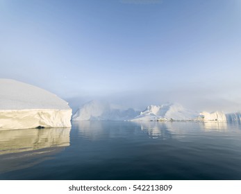 Arctic Icebergs Greenland In The Arctic Sea. You Can Easily See That Iceberg Is Over The Water Surface, And Below The Water Surface. Sometimes Unbelievable That 90% Of An Iceberg Is Under Water