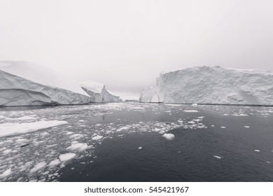 Arctic Icebergs Greenland In The Arctic Sea. You Can Easily See That Iceberg Is Over The Water Surface, And Below The Water Surface. Sometimes Unbelievable That 90% Of An Iceberg Is Under Water