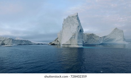 Arctic Icebergs Greenland In The Arctic Sea. You Can Easily See That Iceberg Is Over The Water Surface, And Below The Water Surface. Sometimes Unbelievable That 90% Of An Iceberg Is Under Water.