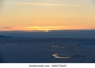 Arctic Landscape In Winter Time. Small River With Ice In Tundra. Sunset.