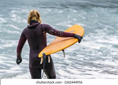 Arctic Surfers Surfing In Norwegian Sea. Unstad, Norwegian Village On Lofoten Islands. Norwegian Sea Coastline. Winter Water Activities Sport.